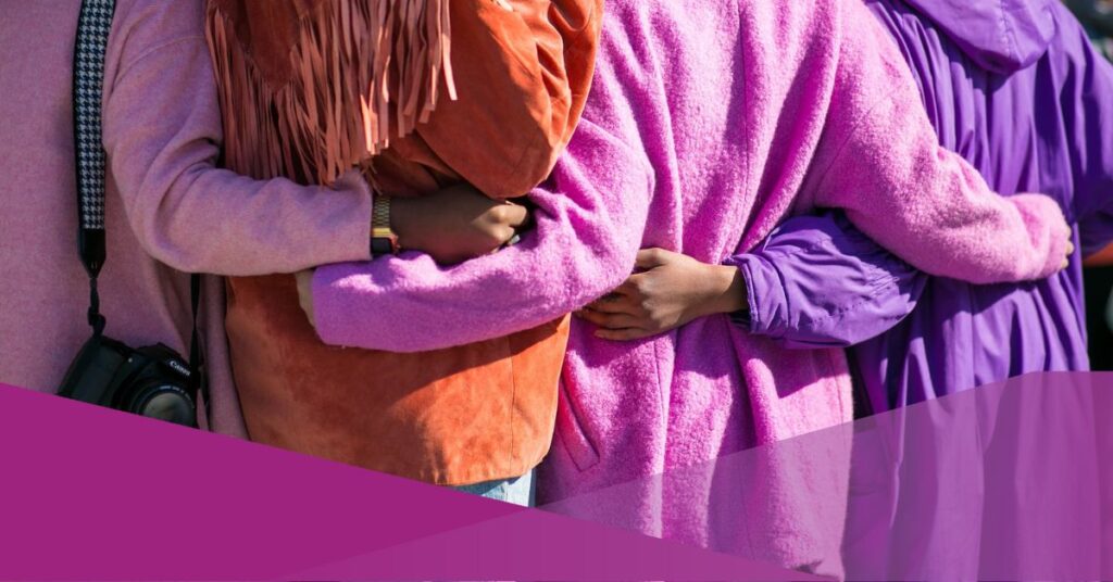 A group of women embraced each other from the back.