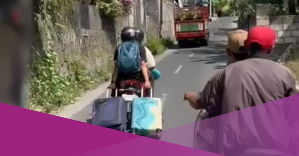 Bali Moment: Tourist Balances Suitcases on Ojek Ride in Bali