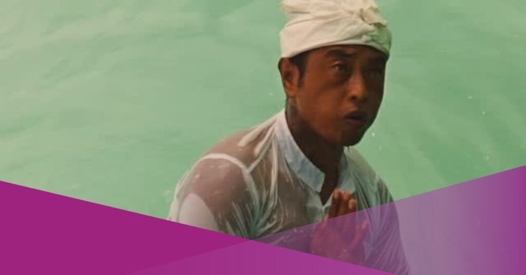 Balinese Surfer Stands Out in Cultural Clothing at Padang-Padang Beach